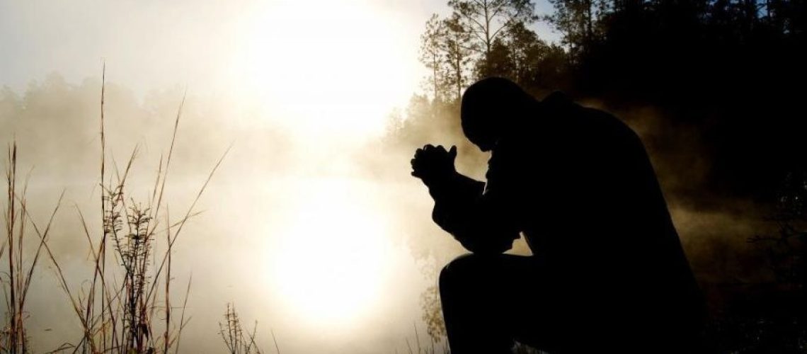 man-praying-in-the-misty-forest